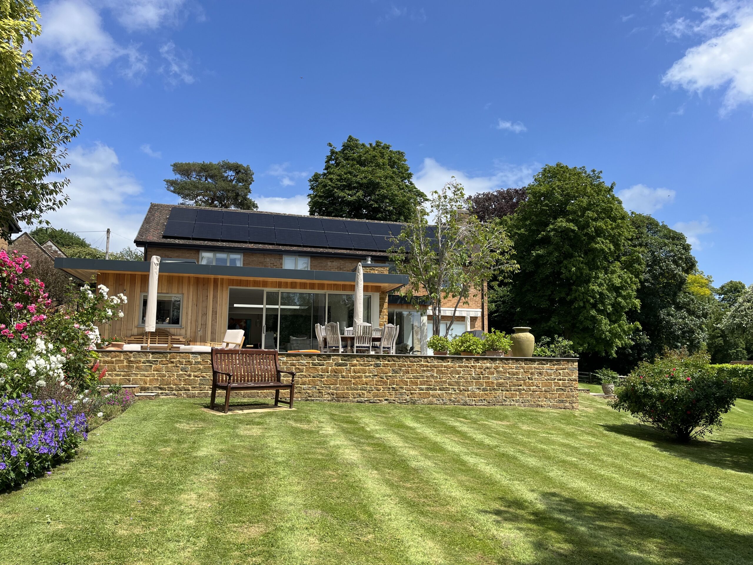 Garden view of roof-mounted solar panels in a family home in Northamptonshire
