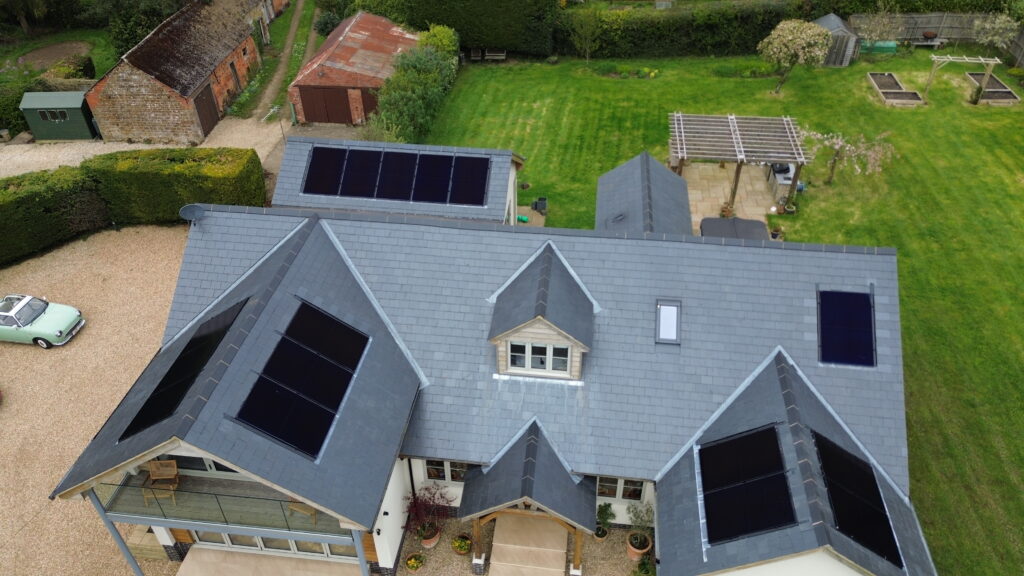 A drone shot of a multi-roof solar panel installation on a detached family house
