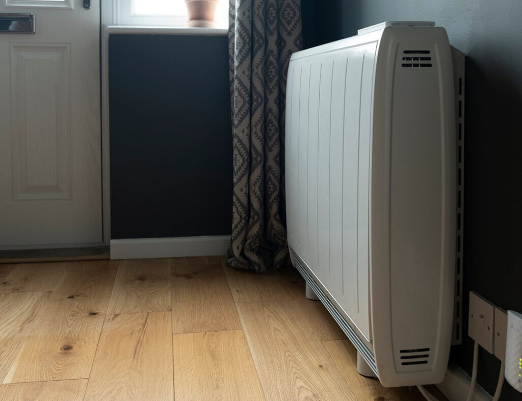 Electric heater installed on hardwood floor in residential property