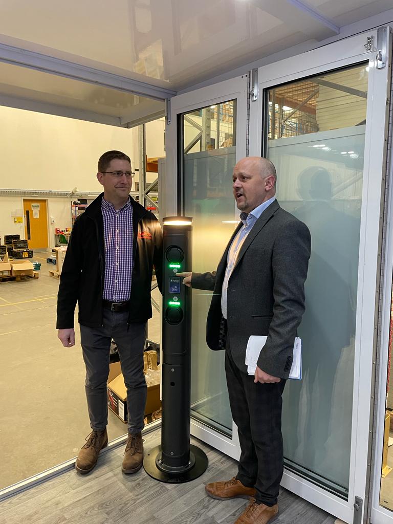 Engineer Mike Neath on a site visit for a commercial EV charger inspection, accompanied by a customer